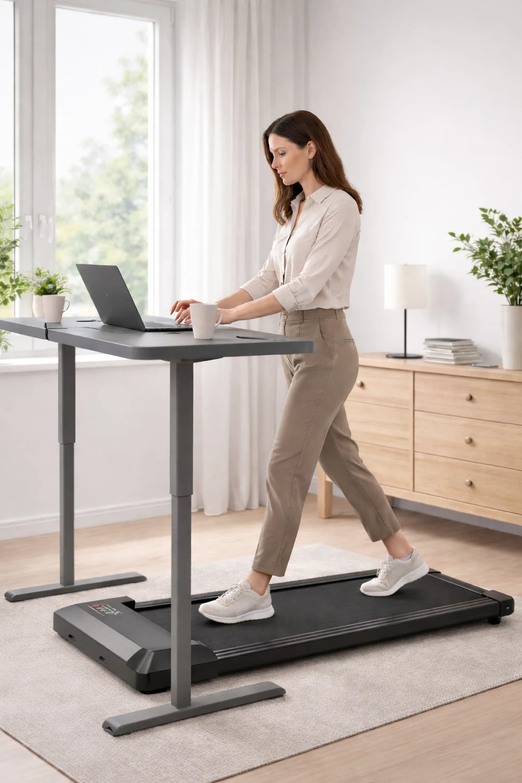 Femme marchant sur un tapis de marche compact MOVAA en télétravail, utilisant un bureau assis-debout.